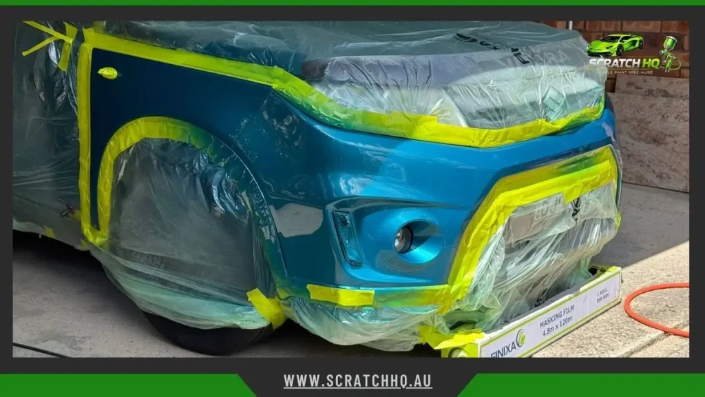 Car bumper and rear panel masked with tape and plastic for scratch repair and paint respray
