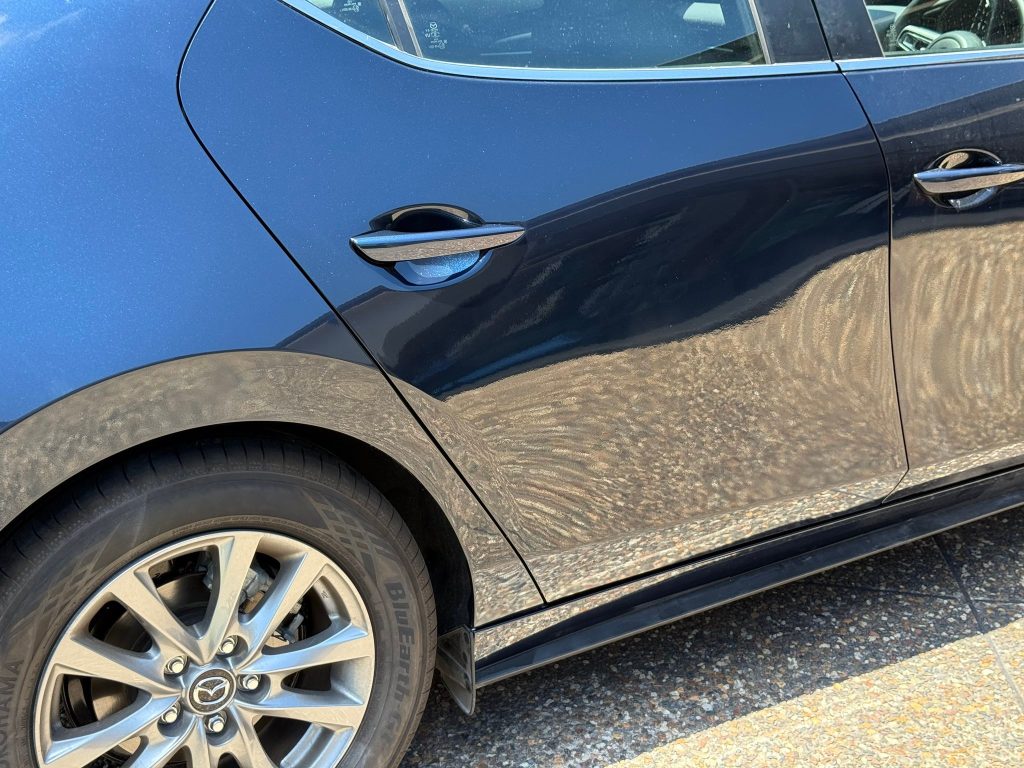 Blue Mazda with visible side door scratches needing car scratch repair in Sydney