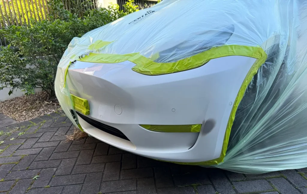 White car bumper with visible scuff marks and paint transfer requiring scratch removal